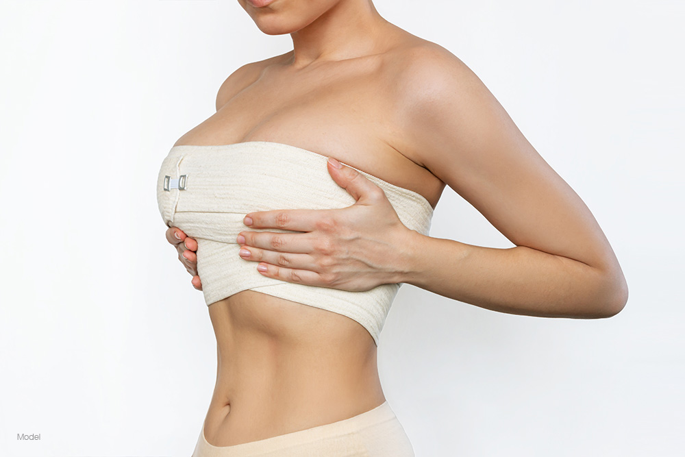 Woman wearing compression bandages on her breasts